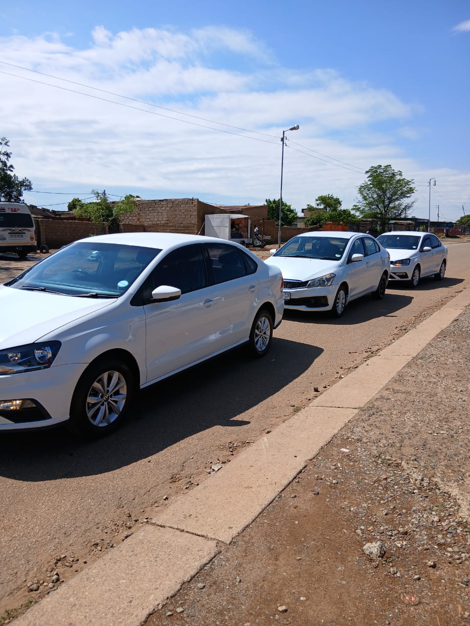 Three white RR Elite sedans ready for private transfers