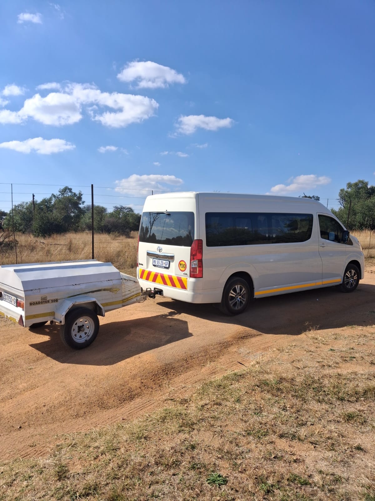 White group shuttle with a luggage trailer